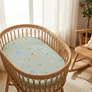 Berceau en rotin avec drap housse bébé vert sauge dans une chambre lumineuse