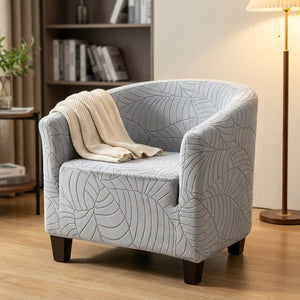 Fauteuil club gris à motif jacquard dans un coin lecture avec plaid et lampadaire