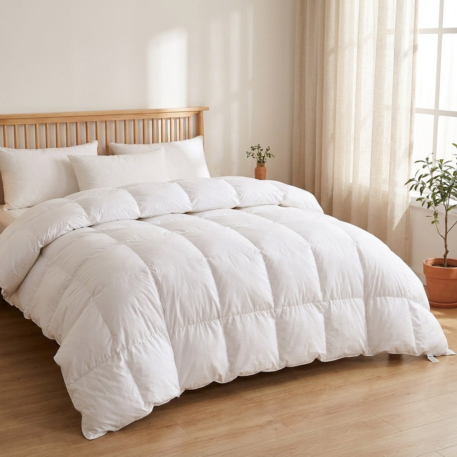 Couette blanche installée sur un grand lit dans une chambre lumineuse au style scandinave