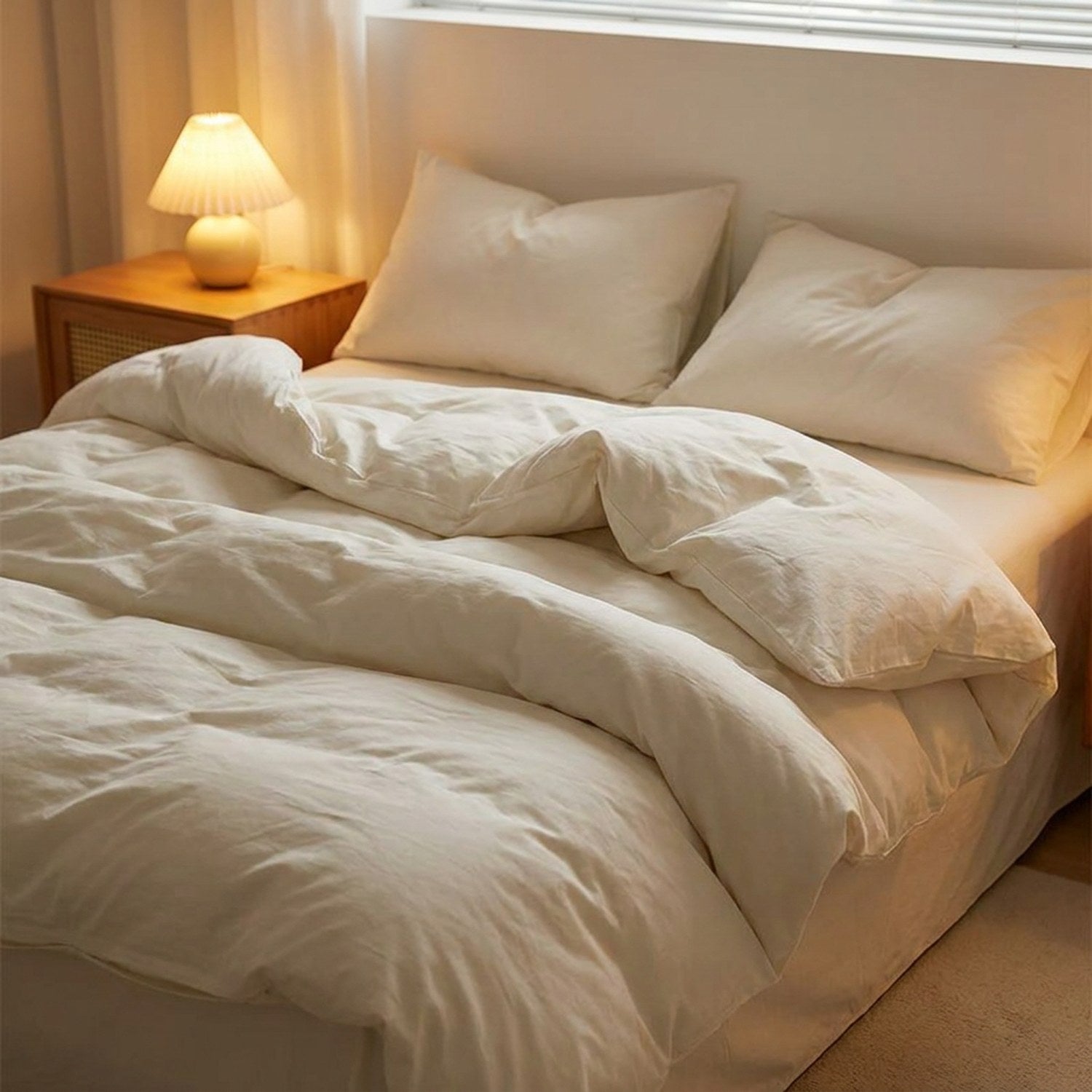 Parure de lit blanche dans une chambre moderne avec table de chevet et lampe