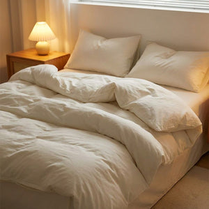 Parure de lit blanche dans une chambre moderne avec table de chevet et lampe