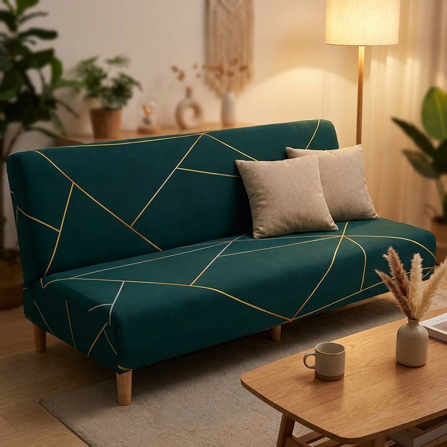 Banquette sans accoudoirs habillée d'une housse vert foncé dans un salon cosy avec coussins beige et table basse en bois