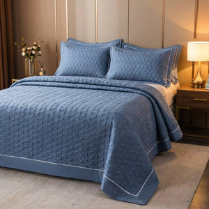 Couvre-lit matelassé bleu sur un lit avec lampe de chevet chaleureuse le soir