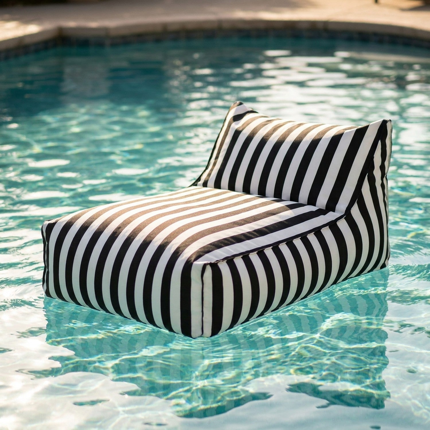 Pouf géant flottant à rayures flottant sur l'eau d'une piscine ensoleillée