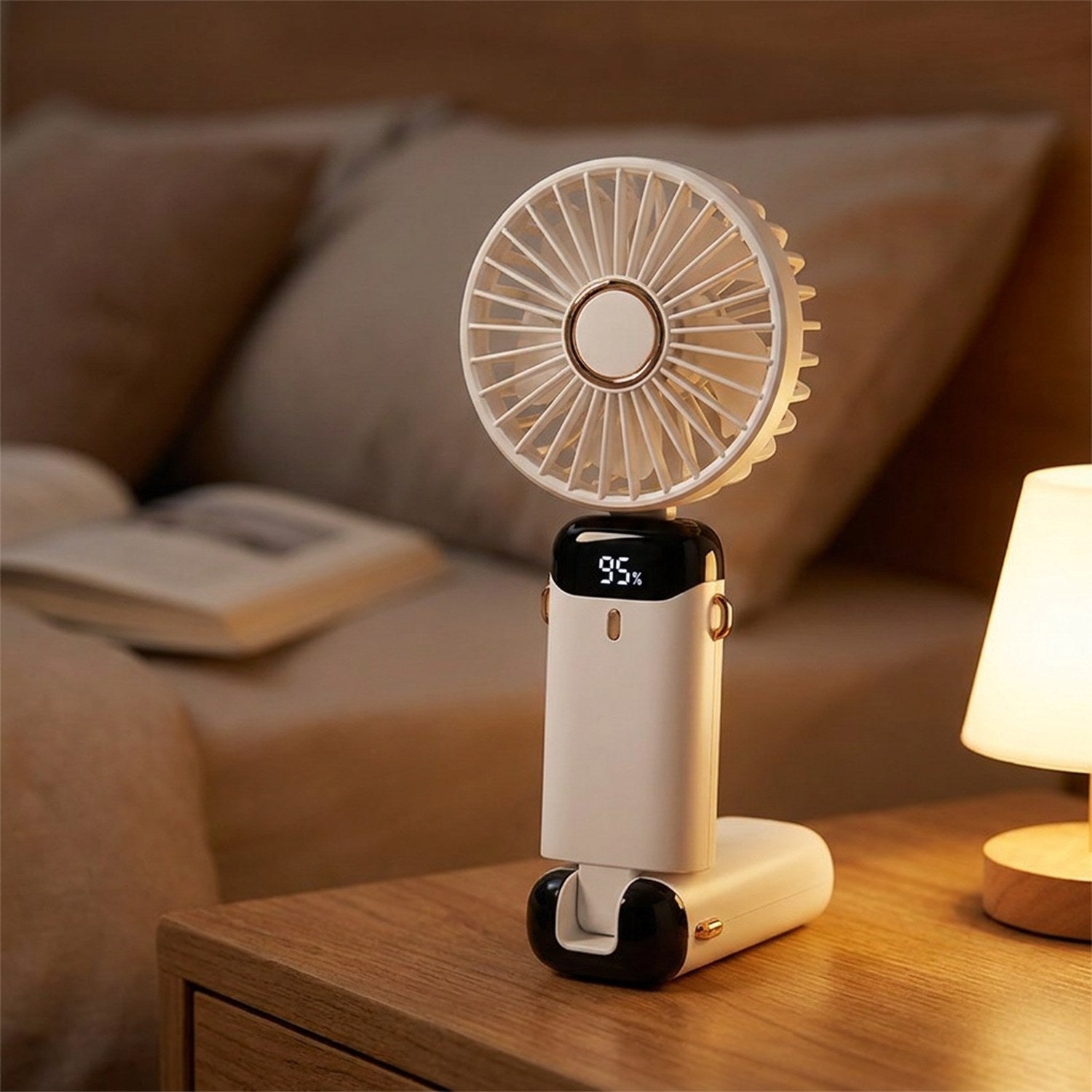 Mini ventilateur portable blanc sur une table de chevet avec lampe chaleureuse