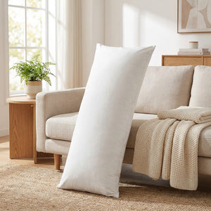 Housse de coussin en velours blanc posée sur un canapé lin dans un salon cosy