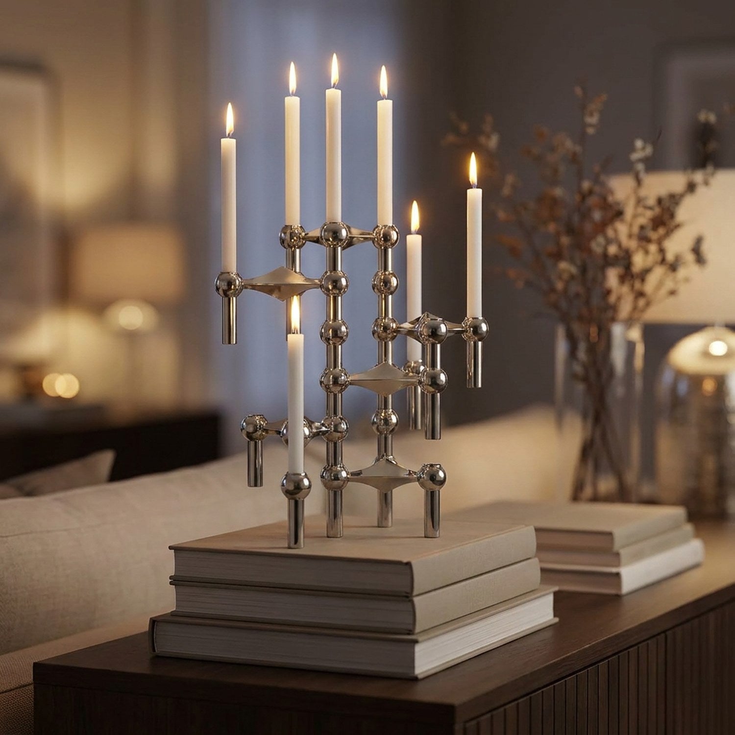 Chandelier modulaire argenté empilé en colonne sur des livres dans un salon