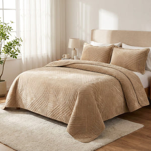 Couvre-lit matelassé en velours beige installé sur un lit dans une chambre chaleureuse et lumineuse