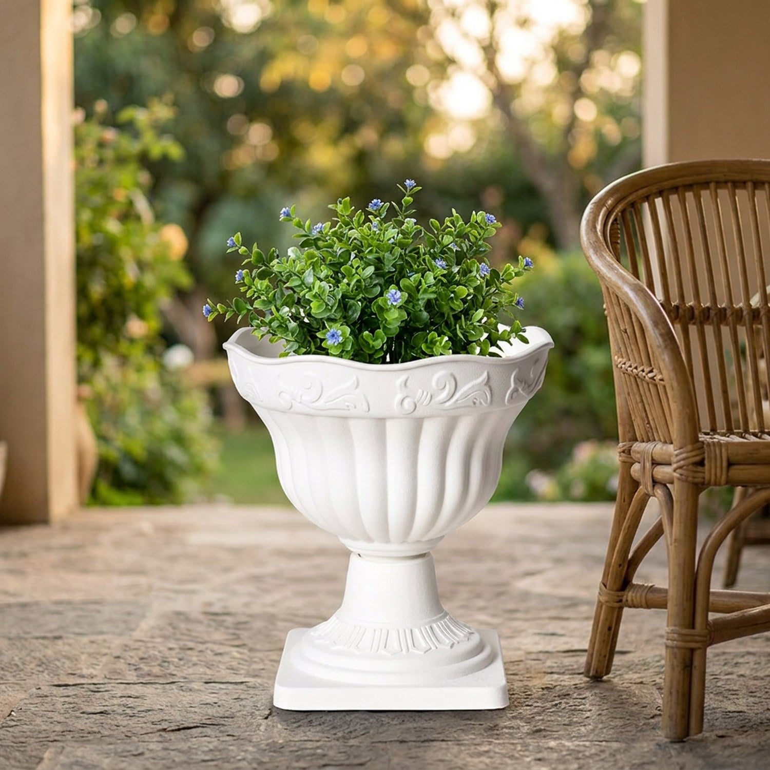 Cache-pot blanc colonne romaine avec une plante verte sur une terrasse