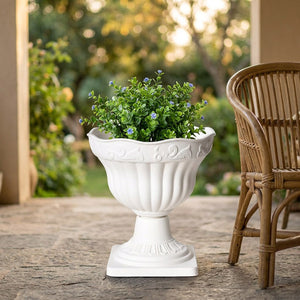 Cache-pot blanc colonne romaine avec une plante verte sur une terrasse