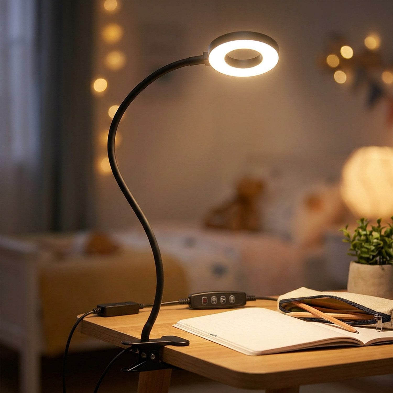 Lampe à pince clipée sur un bureau d'enfant avec cahier ouvert le soir