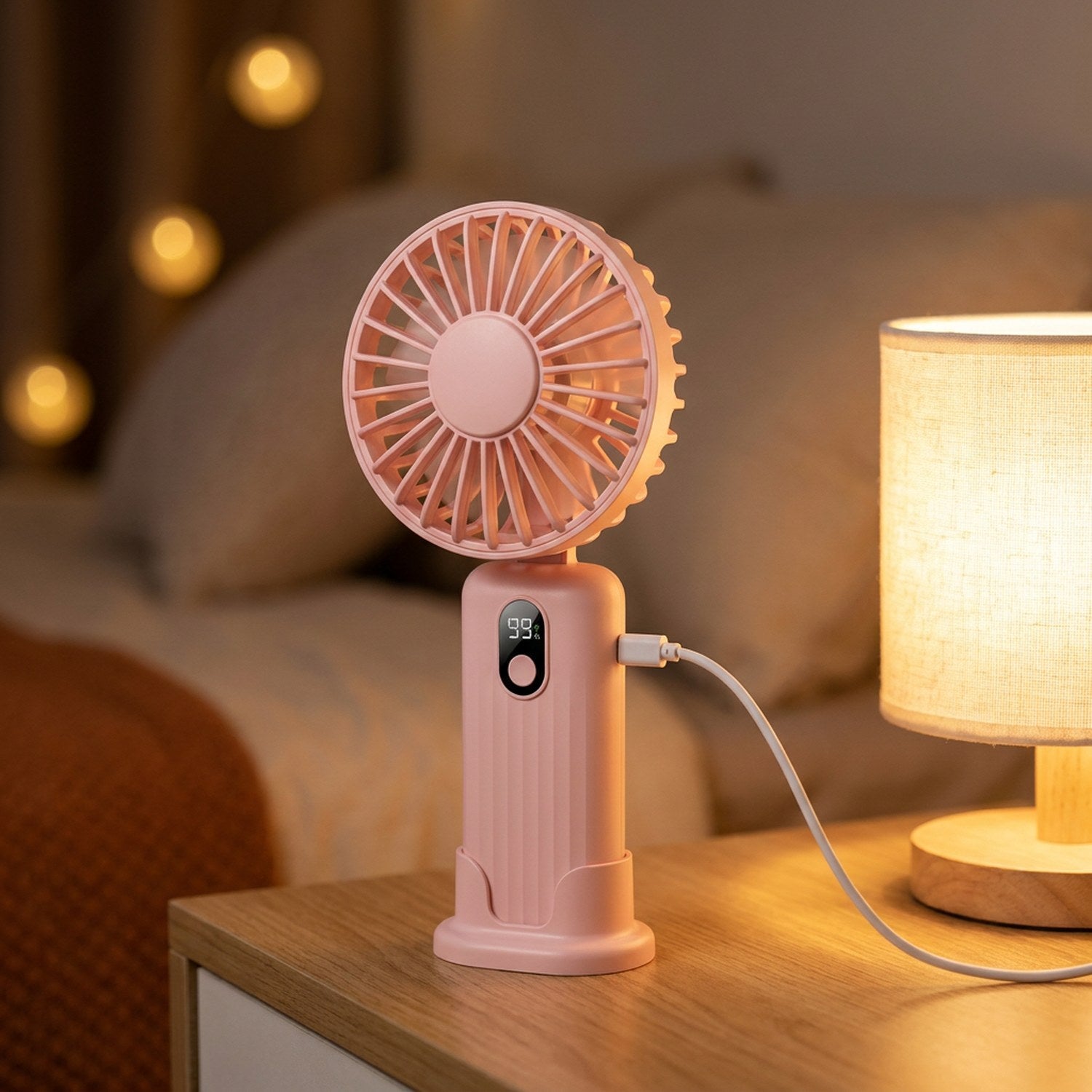 Ventilateur portable sur une table de chevet dans une chambre avec veilleuse allumée