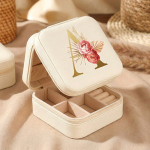 Boîte à bijoux de voyage ouverte montrant son intérieur beige compartimenté