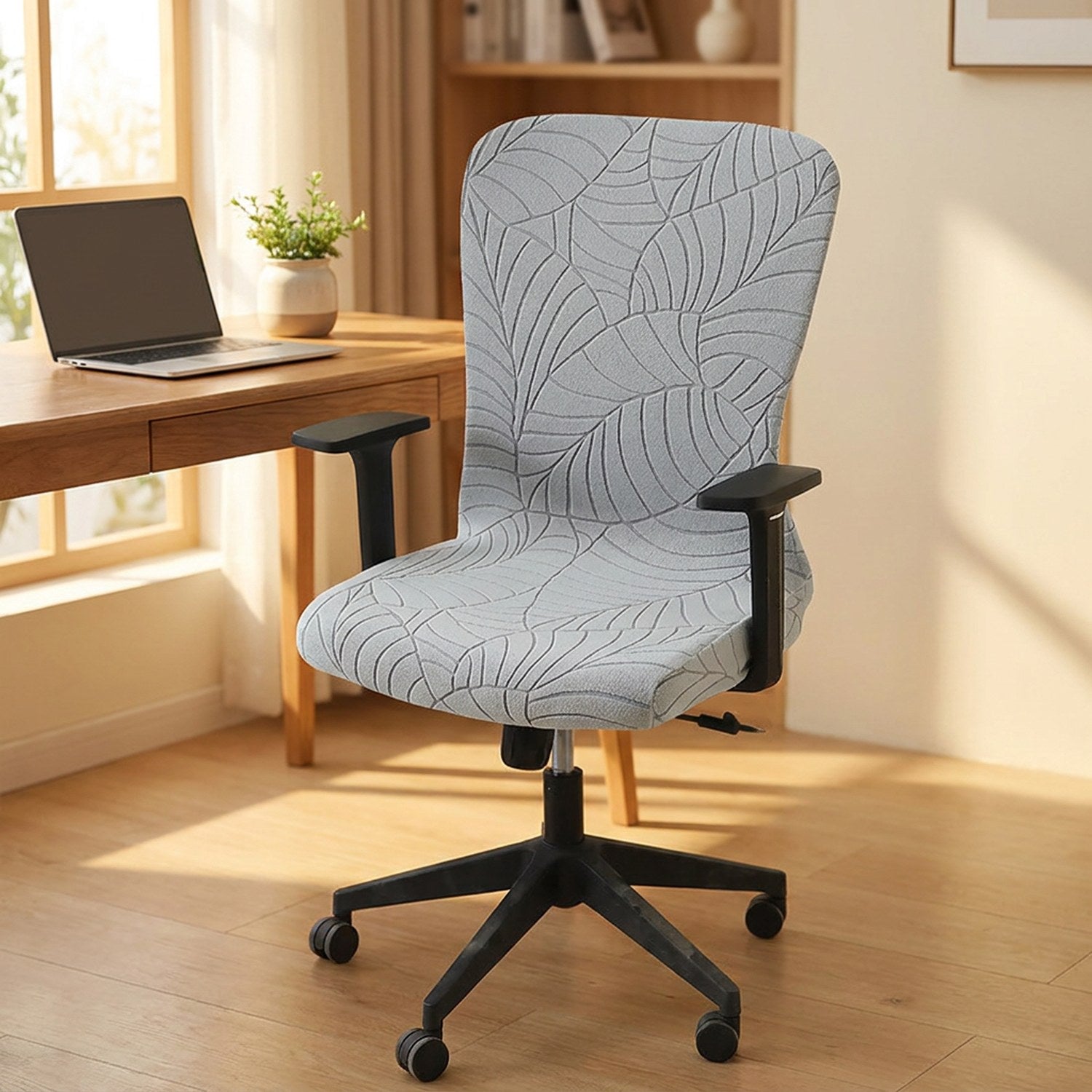 Chaise de bureau habillee d une housse grise a motif feuilles devant un bureau en bois