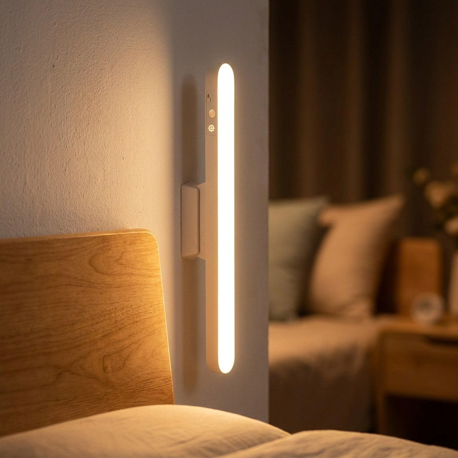 Lampe LED sans fil fixée au mur près d'une tête de lit en bois allumée le soir