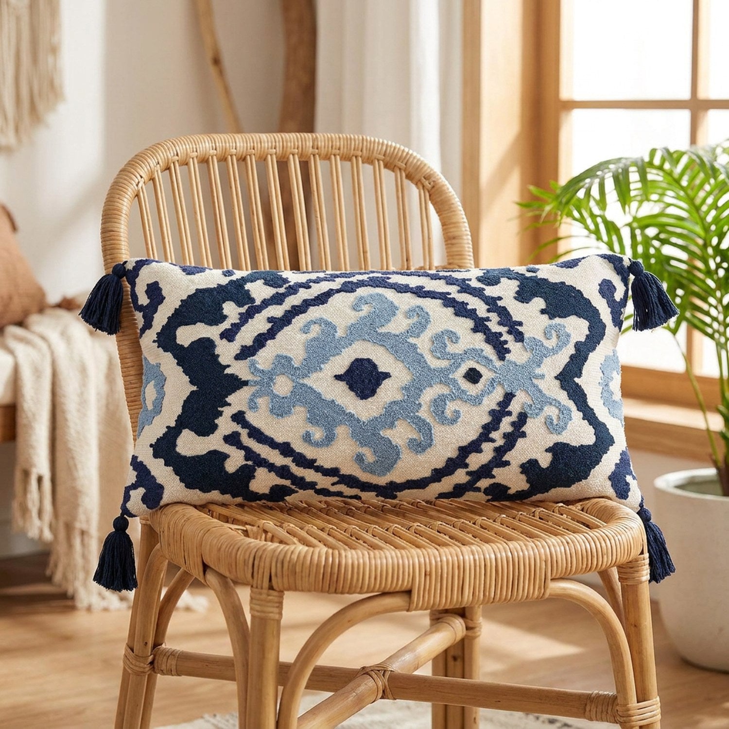 housse de coussin lombaire brodée motif ikat bleu sur un fauteuil en rotin