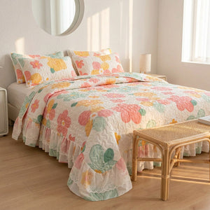 Couvre-lit matelassé fleuri sur un lit fait avec taies assorties dans une chambre chaleureuse