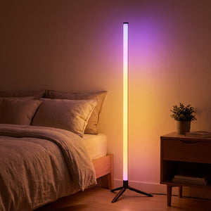 Lampadaire LED RGB allumé dans un coin de chambre avec une lumière violette douce