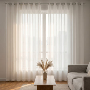 Voilage tulle blanc dans un salon lumineux avec canapé gris et table basse en bois