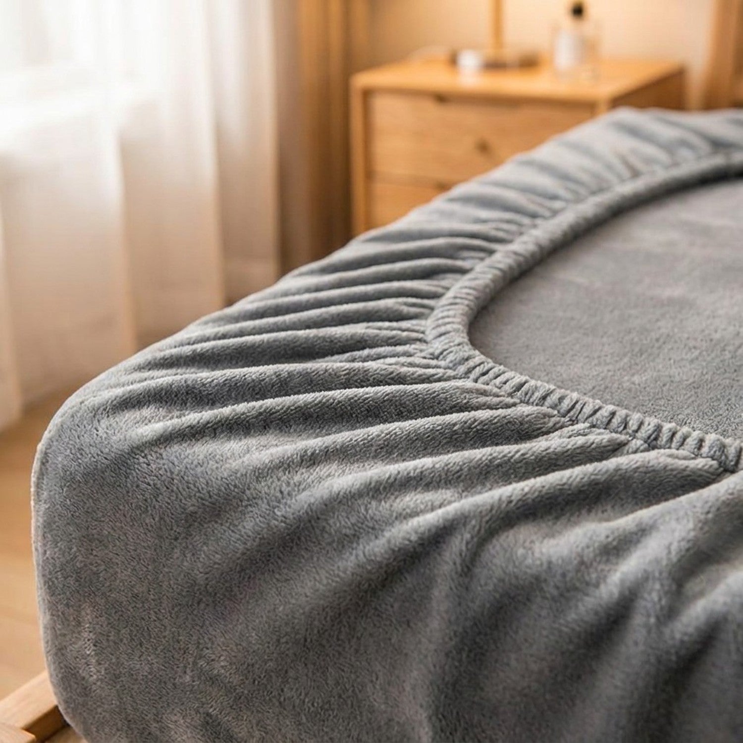 Gros plan sur la texture moelleuse du drap-housse en molleton de corail et son bord élastiqué