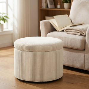 Pouf coffre de rangement utilisé comme repose-pieds devant un fauteuil cosy