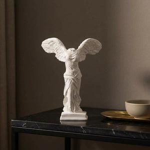 Statue de la victoire grecque ailée sur une console en marbre noir dans une entrée