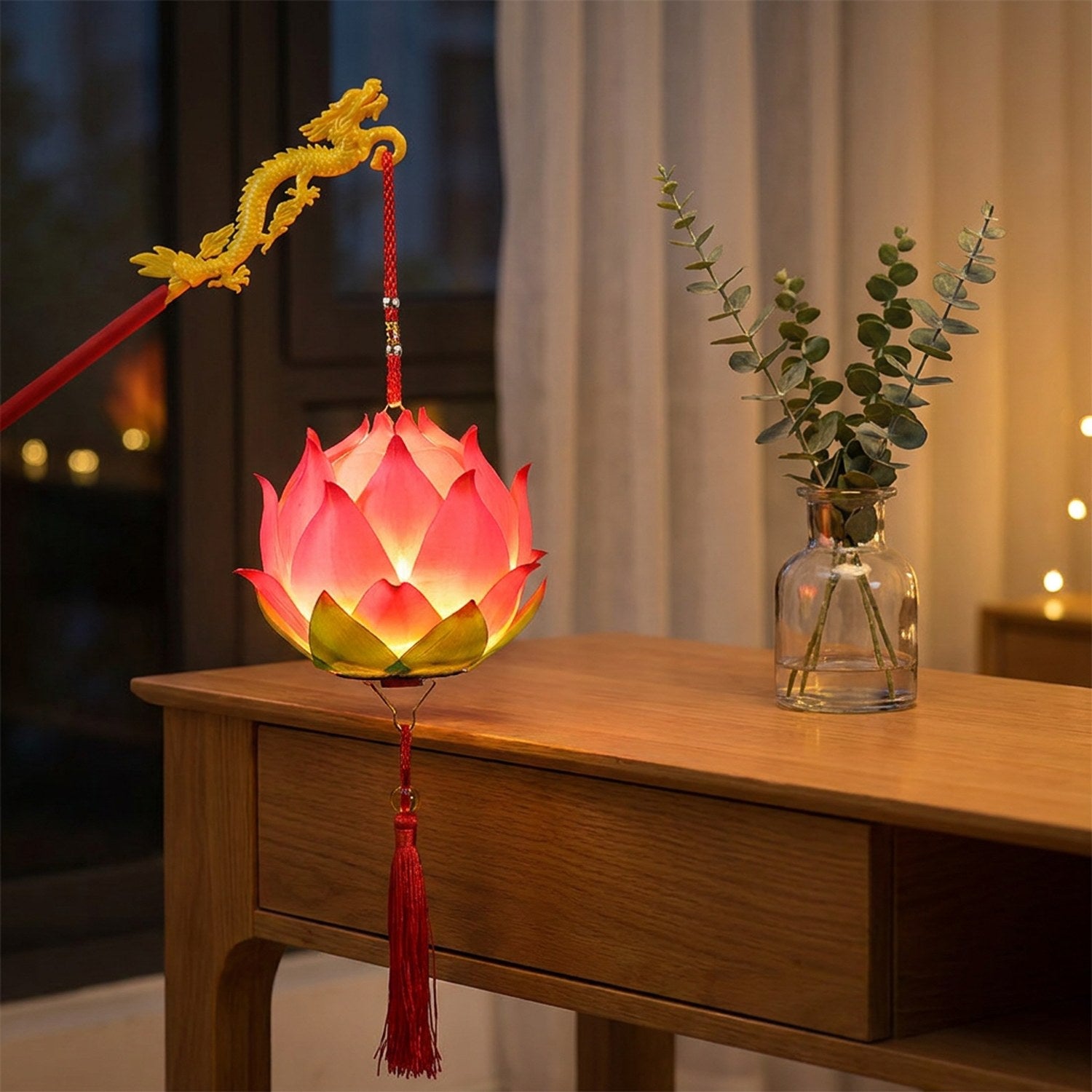 Lanterne lotus rose allumée posée sur une console en bois près d'une fenêtre avec branches d'eucalyptus