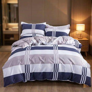 Housse de couette à carreaux marine sur un lit avec table de chevet et lampe allumée