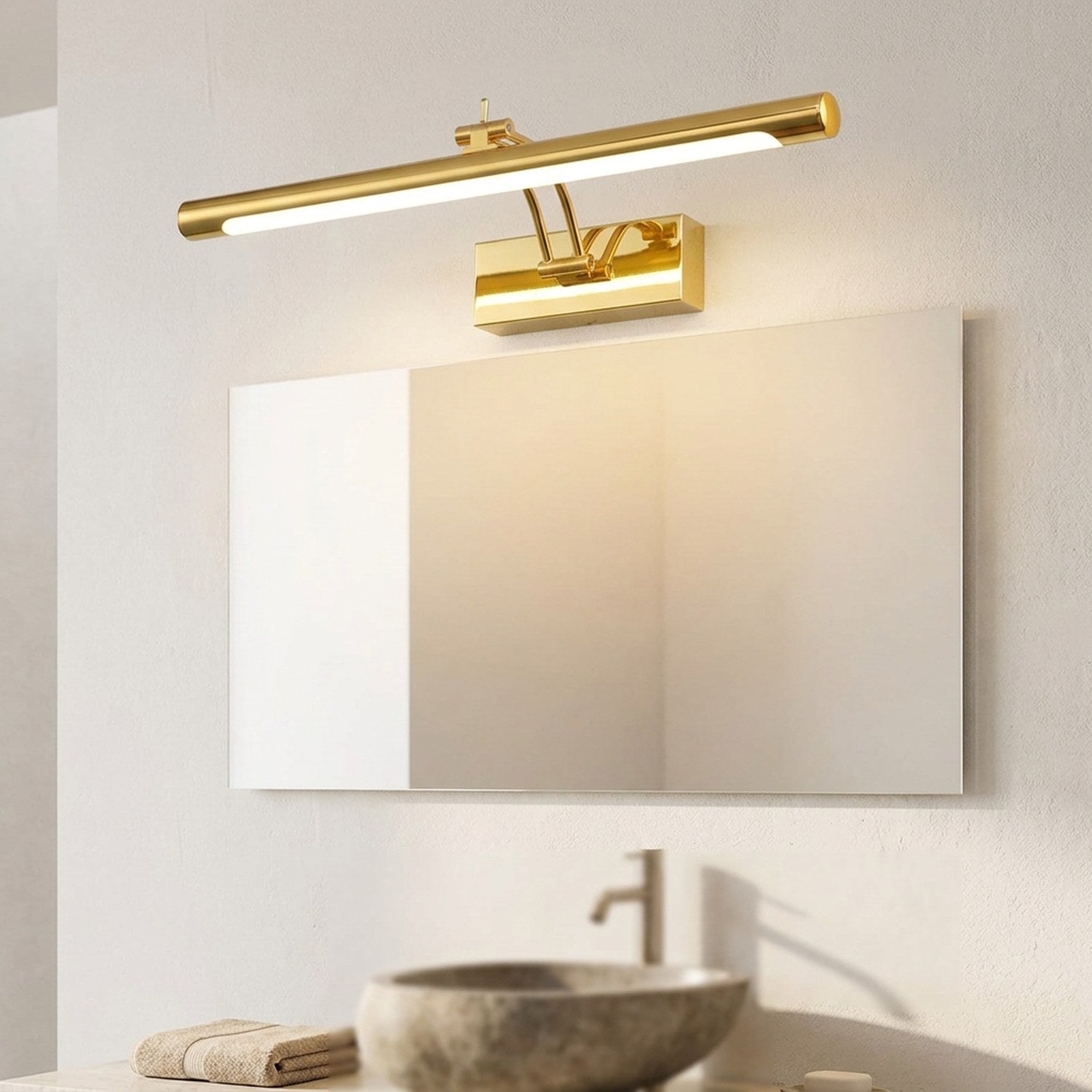 Applique murale miroir LED dorée allumée au-dessus d'un grand miroir de salle de bains lumineuse