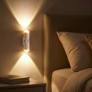 Applique murale LED allumée en blanc chaud fixée près d un lit dans une chambre cosy