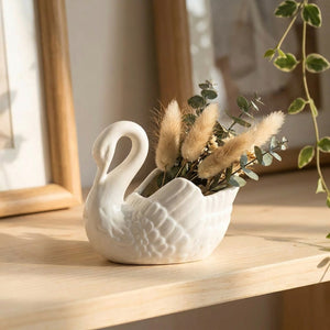 Vase cygne blanc avec pampa et eucalyptus sur une étagère lumineuse