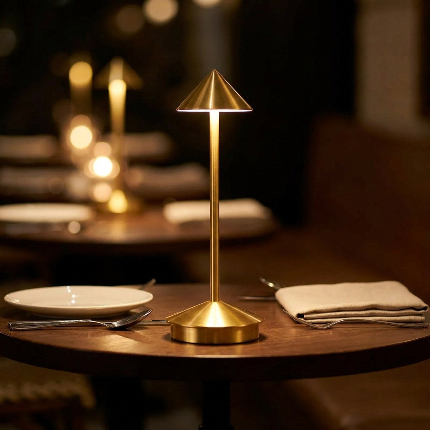 Lampe de table dorée allumée sur une table de restaurant intime