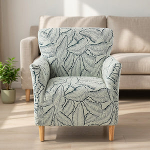 Housse de fauteuil verte à motif de feuilles jacquard sur un fauteuil dans un salon lumineux