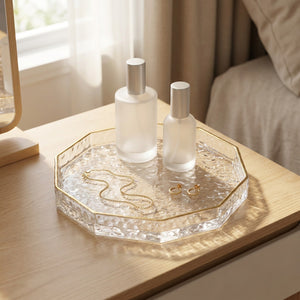 Plateau en verre à facettes garni de flacons de parfum et de bijoux sur une coiffeuse