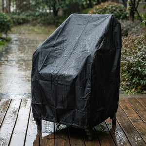 Housse de protection imperméable sur des chaises de jardin sous la pluie avec gouttes perlant sur le tissu