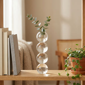 Vase en verre à bulles sur une étagère en bois avec des livres et une plante