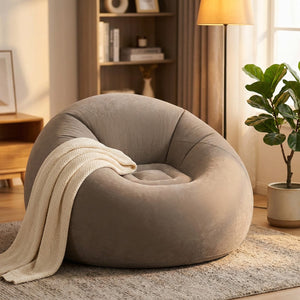 Fauteuil gonflable gris dans un coin salon cosy avec lampadaire et plaid