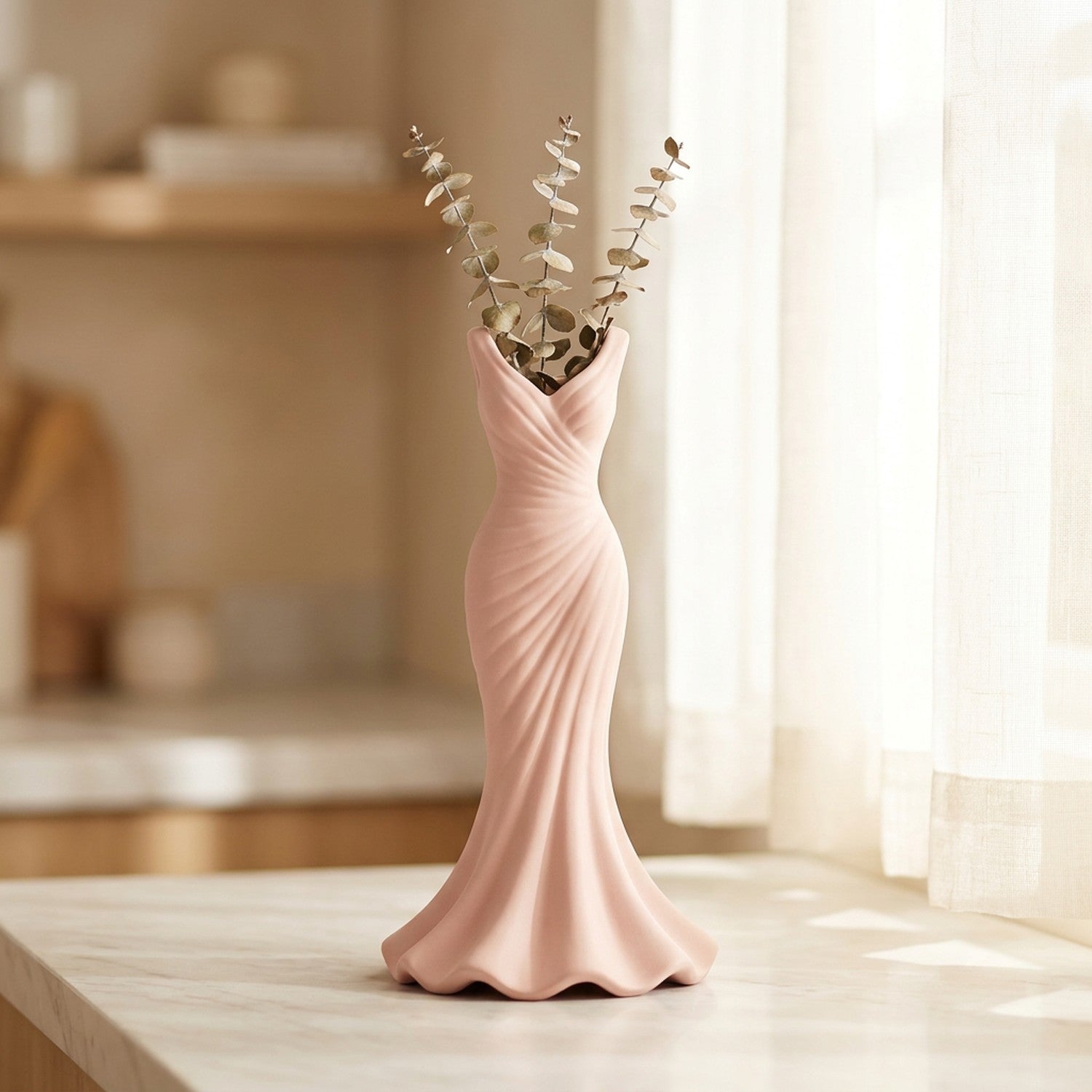 Vase rose en forme de robe avec eucalyptus séché sur une surface en marbre
