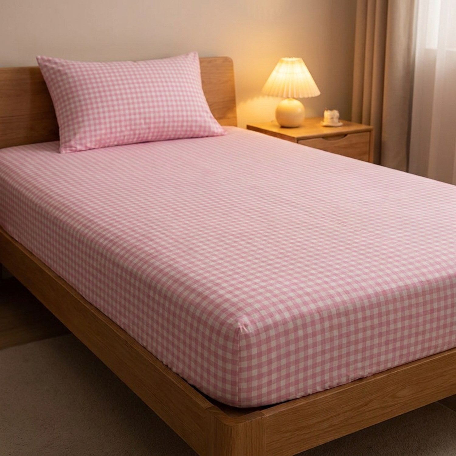 Drap-housse à carreaux rose près d'une table de chevet avec lampe allumée