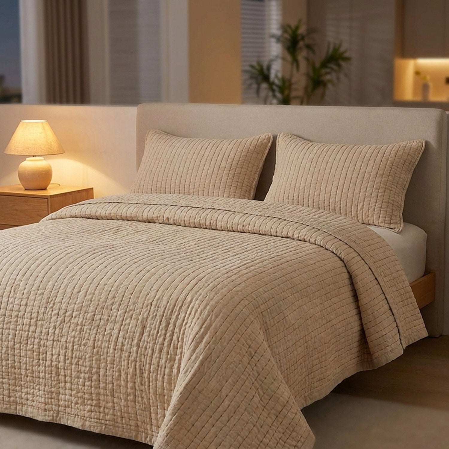 Couvre-lit matelassé beige sur un lit dans une chambre chaleureuse avec lampe de chevet allumée