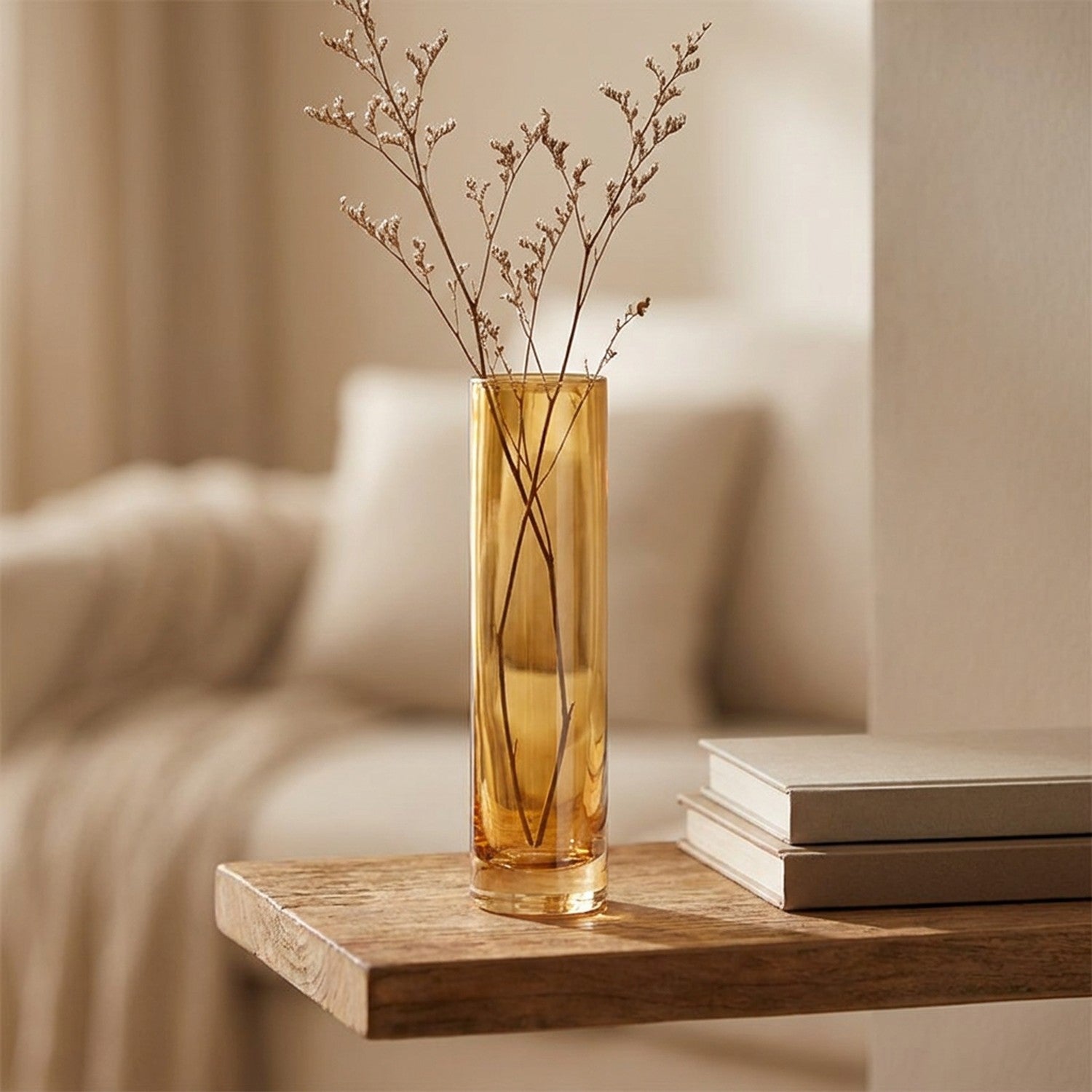 Vase en verre coloré ambré avec une branche séchée sur une étagère en bois