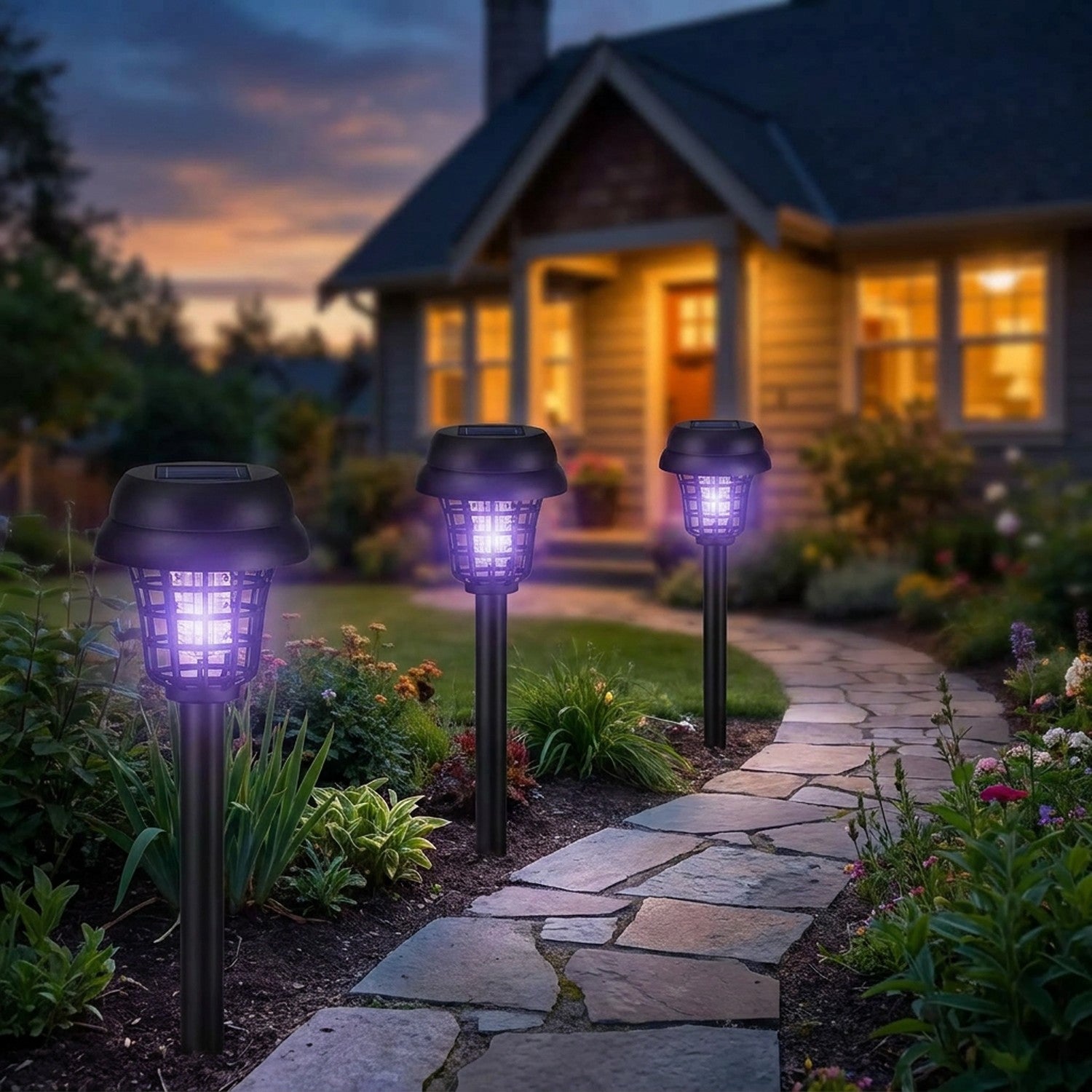 Plusieurs lampes solaires anti-moustiques bordant une allée de jardin éclairée au crépuscule
