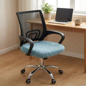 Chaise de bureau habillée d'une housse d'assise bleue installée devant un bureau en bois avec ordinateur portable