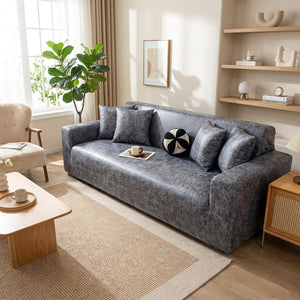 Salon moderne avec canapé trois places recouvert d'une housse grise et coussins assortis