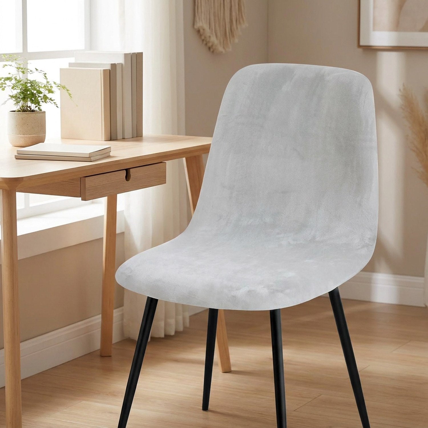 Housse de chaise en velours gris sur une chaise de bureau près d une fenêtre