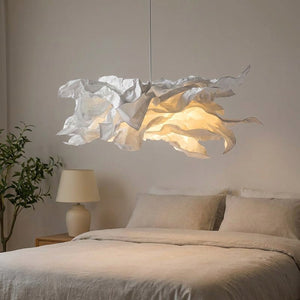 Lustre nuage en papier suspendu au-dessus d'un lit dans une chambre cosy le soir