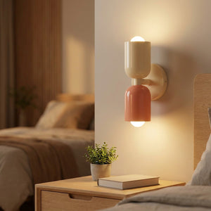 Applique murale LED double tête allumée au-dessus d'une table de chevet en bois