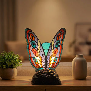 Lampe style Tiffany papillon en vitrail allumée sur une console de salon près d'une plante verte
