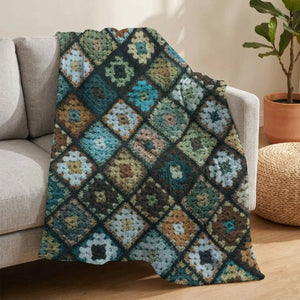 Plaid patchwork multicolore drapé sur le fauteuil d'un canapé gris avec plante et pouf en fibres naturelles