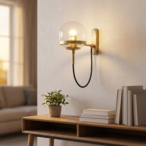 Applique murale boule de verre dorée au dessus d'une console dans un salon lumineux